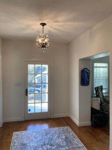 ein leeres Wohnzimmer mit einem Kronleuchter und einer Tür in der Unterkunft The Jackson House in Jackson