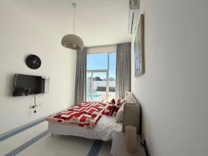 a bedroom with a bed and a large window at Sun & moon in Būbādī