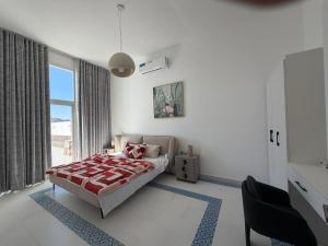 a bedroom with a bed and a large window at Sun & moon in Būbādī