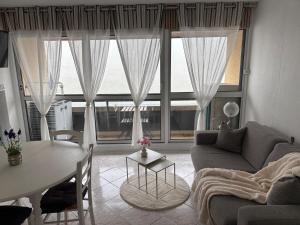 a living room with a table and a large window at Résidence MAYA in Saint-Lary-Soulan
