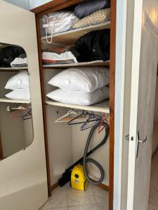 a room with a closet with pillows and a hose at Résidence MAYA in Saint-Lary-Soulan