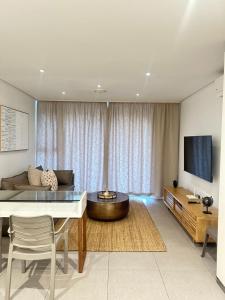 a living room with a couch and a table at Pebble Beach Sibaya 146 in Sibaya