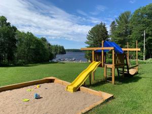 a playground with a slide in the grass at Muskoka 4-Bedroom Cottage in Port Carling