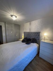 a bedroom with a white bed and a dresser at Sunshine apartment in Stockholm