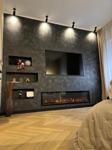 a living room with a fireplace with a tv on a wall at Harison Rynek in Bolesławiec
