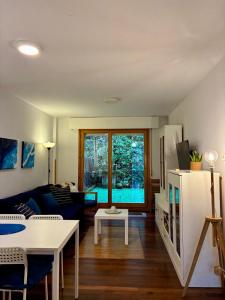 a living room with a couch and a table at Casa de Claudia Comillas- Jardín privado - A 10 metros del Capricho de Gaudí in Comillas