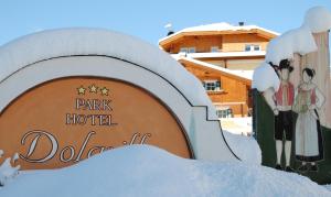 un panneau indiquant la doline du parc de l'hôtel dans la neige dans l'établissement Dolasilla Park Hotel, à Vigo di Fassa