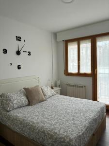 a bedroom with a bed and a clock on the wall at Casa de Claudia Comillas- Jardín privado - A 10 metros del Capricho de Gaudí in Comillas +33 photos