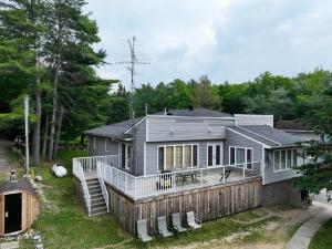 a home with a large deck and a house at Muskoka 4-Bedroom Cottage in Port Carling