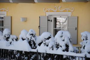 a house with snow on the fence at Dolasilla Park Hotel in Vigo di Fassa
