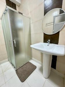 un bagno con doccia, lavandino e specchio di Monopolio gar tgv 5 min a Tangeri Altre 3 foto