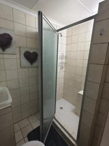 a shower with a glass door in a bathroom at 37 on Bell self catering accommodation in Harrismith