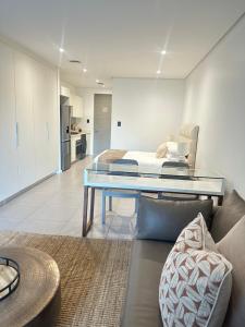 a living room with a couch and a glass table at Pebble Beach Sibaya 146 in Sibaya