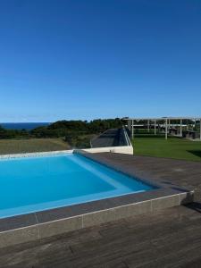 a blue swimming pool with the ocean in the background at Pebble Beach Sibaya 146 in Sibaya +4 photos