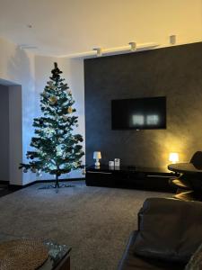 een kerstboom in een woonkamer met een bank bij Apartament Leonardo in Bolesławiec