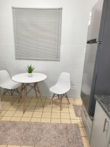 a kitchen with a table and two white chairs at 37 on Bell self catering accommodation in Harrismith +4 photos