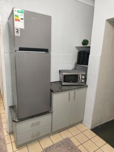 a small kitchen with a refrigerator and a microwave at 37 on Bell self catering accommodation in Harrismith