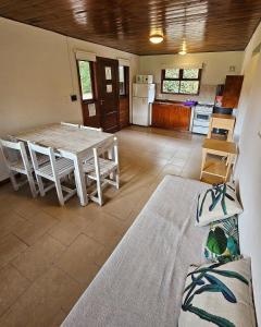 a living room with a table and a kitchen at KEIKI Complejo Cabañas in Mar del Plata
