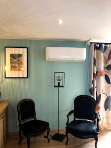 two chairs in a room with blue walls at Le Passiflore in Beuvron-en-Auge