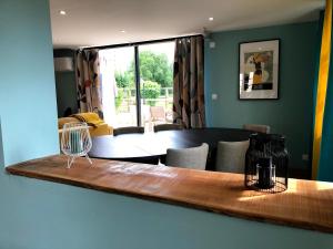 a dining room with a table and a living room at Le Passiflore in Beuvron-en-Auge