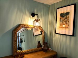 a mirror sitting on top of a wooden table at Le Passiflore in Beuvron-en-Auge