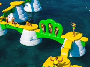 een groep mensen op een opblaasbaar park in het water bij La Garçonnière Logement calme à proximité de Langres in Champigny-lès-Langres