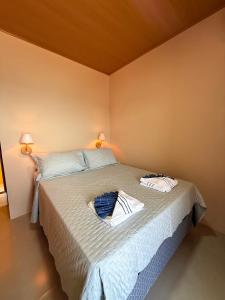 a bedroom with a bed with two towels on it at Casa Sol da Ilha in Angra dos Reis