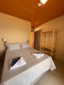 a bedroom with a bed with two towels on it at Casa Sol da Ilha in Angra dos Reis