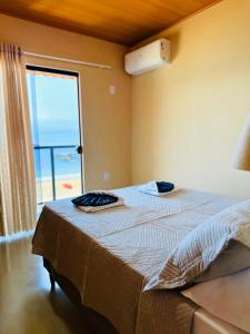 a bedroom with a bed with a view of the ocean at Casa Sol da Ilha in Angra dos Reis