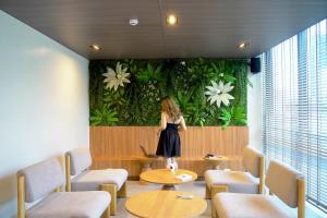 Una donna in piedi davanti a un muro con dei fiori di Kokotel Cebu Adira a Cebu City