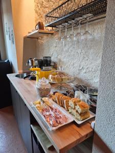 un bancone con molti tipi di pasticcini diversi di Dolcevita guest house a Torreano