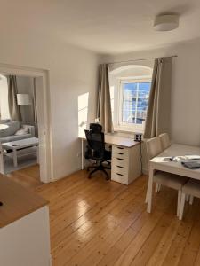 a living room with a desk and a bedroom at Yellow House Apartments - Top 3 in Steyr