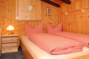 a bedroom with two beds with red and white pillows at Appartment Valnova / Barga in Partenen