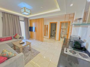 a living room with a couch and a tv at Great Holiday suites in Agadir