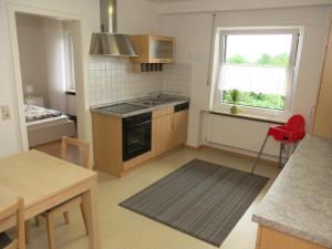 a small kitchen with a red chair and a window at Ferienwohnung Billich in Bad Bellingen
