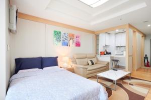 a bedroom with a bed and a chair and a kitchen at Gangnam Opal in Seoul