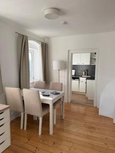 a white dining room with a table and chairs at Yellow House Apartments - Top 3 in Steyr