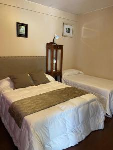 twee bedden in een hotelkamer naast elkaar bij Hotel Casa del Peregrino in Salta
