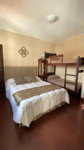 een slaapkamer met een bed en 2 stapelbedden bij Hotel Casa del Peregrino in Salta