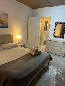 a bedroom with a large bed and a bathroom at Seafront place Spinola StJulians in St. Julianʼs