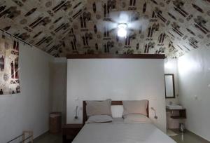 a bedroom with a large bed with a ceiling with photographs at Kabacoto Lodges in Darou Rhamane