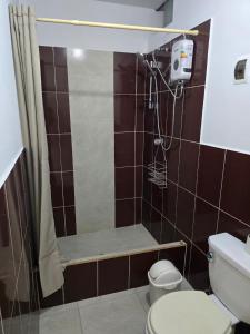 een badkamer met een douche, toilet en wastafel bij Casa Wavve in Huanchaco