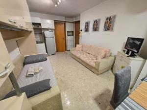 a living room with a couch and a tv at City Center Piazza Studio in Tirana