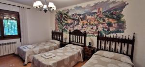 a room with two beds and a painting on the wall at Casa Rural Ruiz Hernando in Villanueva del Arzobispo +55 photos