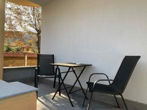 a table and chairs in a room with a window at Пътепис in Bratsigovo