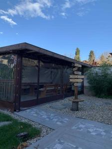 a wooden pavilion with a bench in a yard at Пътепис in Bratsigovo