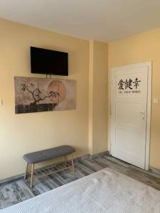 a room with a bed and a tv and a door at Пътепис in Bratsigovo