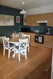 a kitchen with a table and chairs in a kitchen at Fox Cottage in Moffat