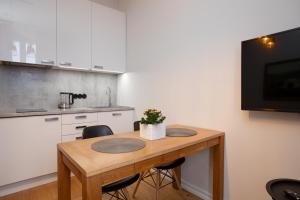 a kitchen with a wooden table with two chairs at Cozy Duo Loft Studio in Tartu +8 photos