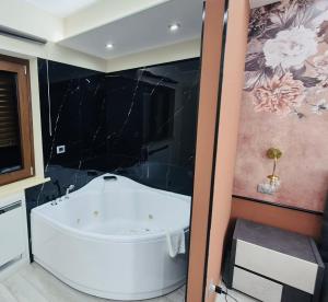 bagno con vasca bianca in una stanza di B&B Golden House & spa a Rose